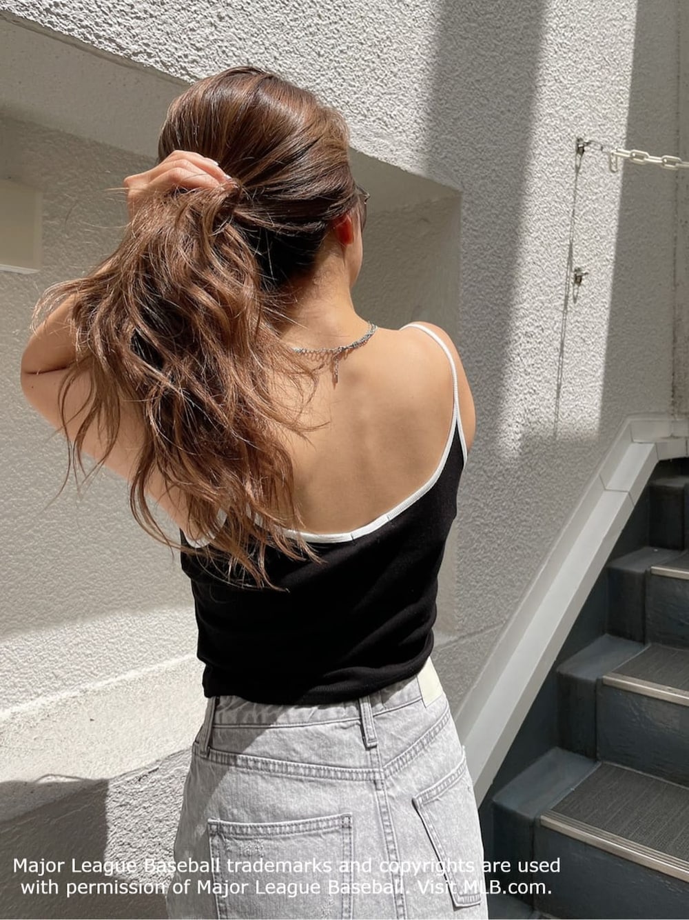 ホワイト系のパンプス、グレー系のデニムスカート、ブラック系のキャミソールを着用したレディースの夏コーディネートの6枚目の写真
