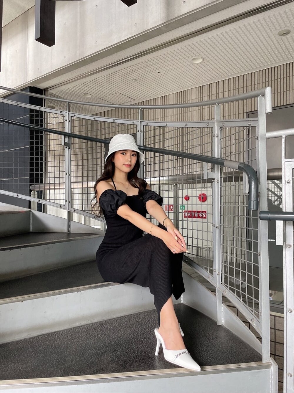 ブラック系のワンピース、ホワイト系のハットを着用したレディースの夏コーディネートの2枚目の写真