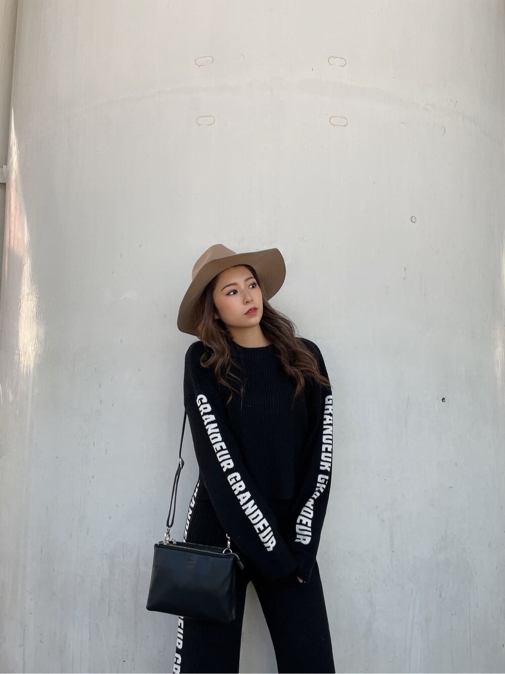 ブラック系のパンプス、ブラック系のニット/セーター、ブラック系のショルダーバッグを着用したレディースの冬コーディネートの5枚目の写真