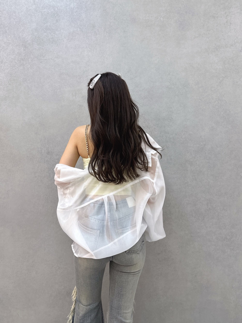 イエロー系のキャミソール、ホワイト系のシャツ/ブラウス、ブルー系のデニムパンツを着用したレディースの春コーディネートの4枚目の写真