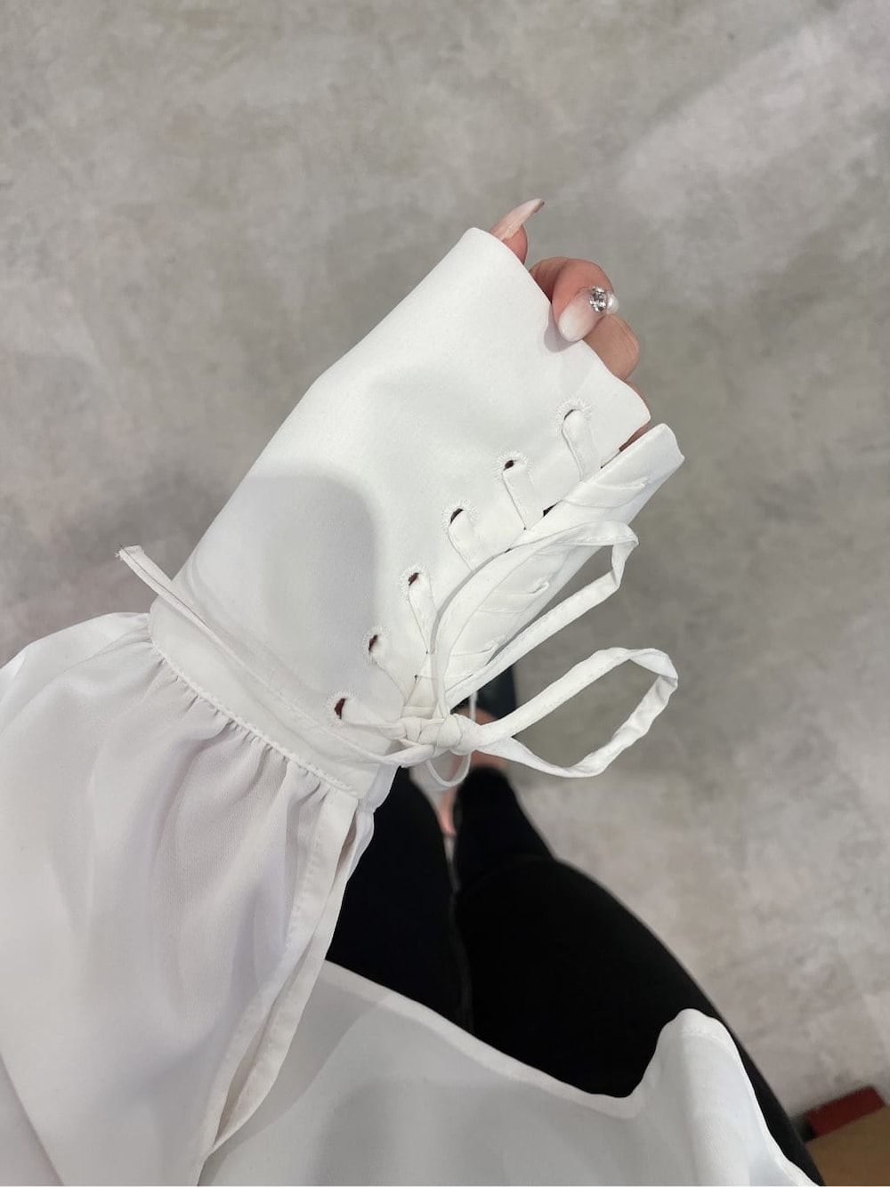 ブラック系のパンプス、ホワイト系のシャツ/ブラウス、ブラック系のデニムパンツを着用したレディースの冬コーディネートの6枚目の写真