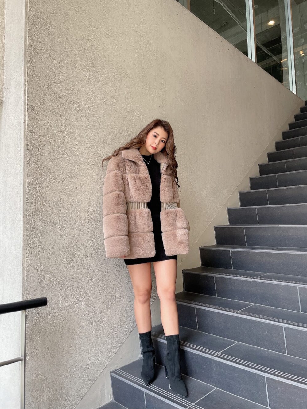 ブラック系のブーツ、ベージュ系のその他アウター、ブラック系のワンピースを着用したレディースの冬コーディネートの4枚目の写真