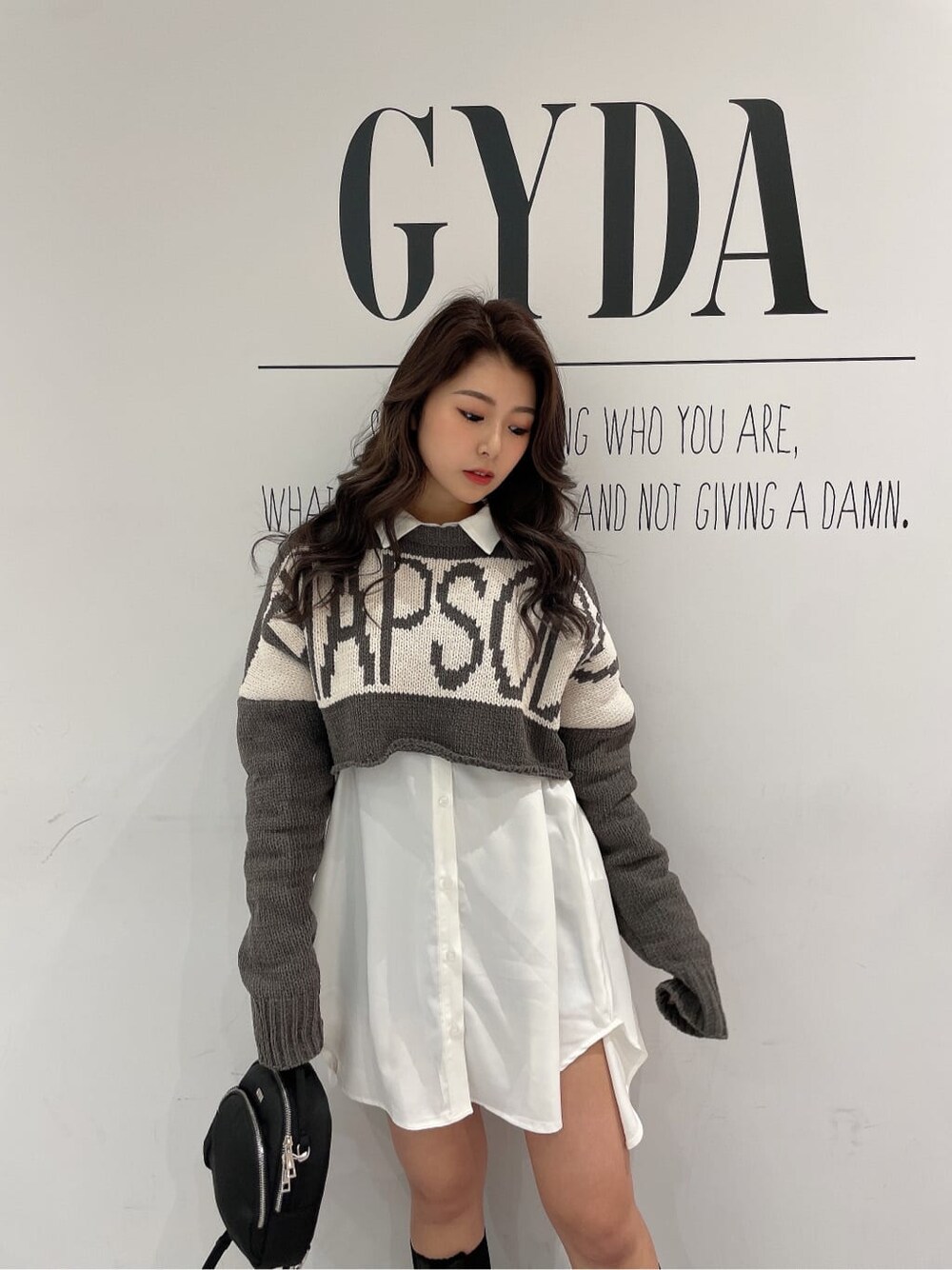 ブラック系のその他シューズ、ブラック系のバックパック/リュック、ホワイト系のシャツ/ブラウスを着用したレディースの冬コーディネートの7枚目の写真