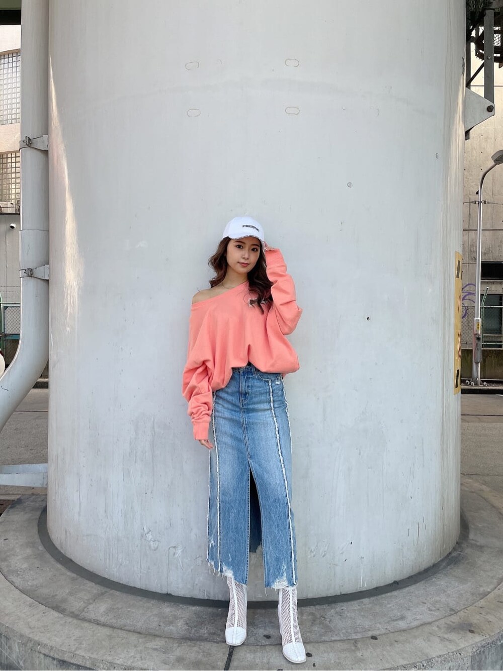 ホワイト系のブーツ、オレンジ系のスウェット、ブルー系のデニムスカートを着用したレディースの冬コーディネートの3枚目の写真