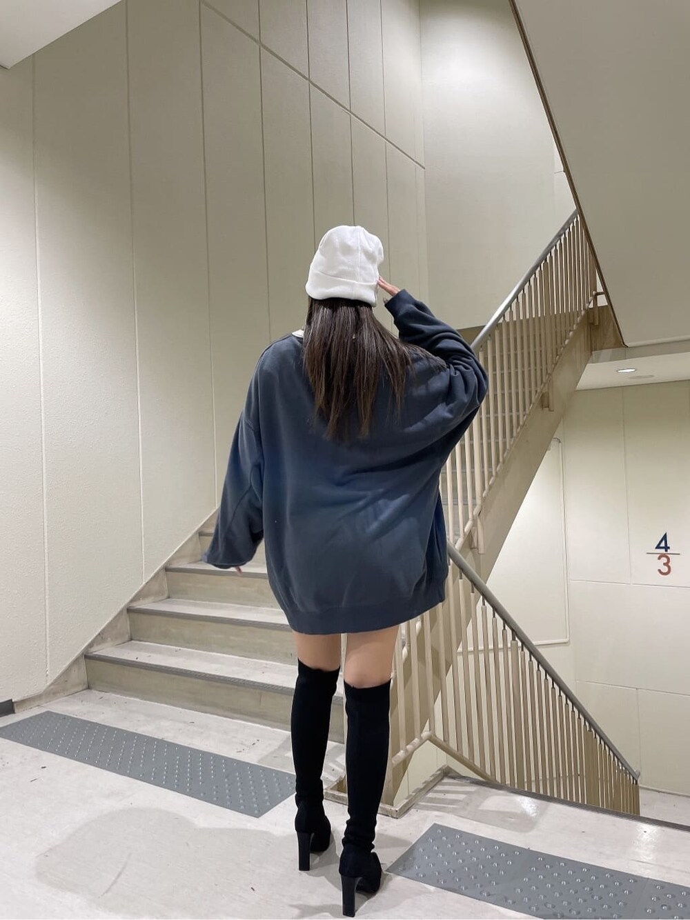 ブラック系のブーツ、グレー系のスウェット、ホワイト系のニットキャップ/ビーニーを着用したレディースの秋コーディネートの3枚目の写真