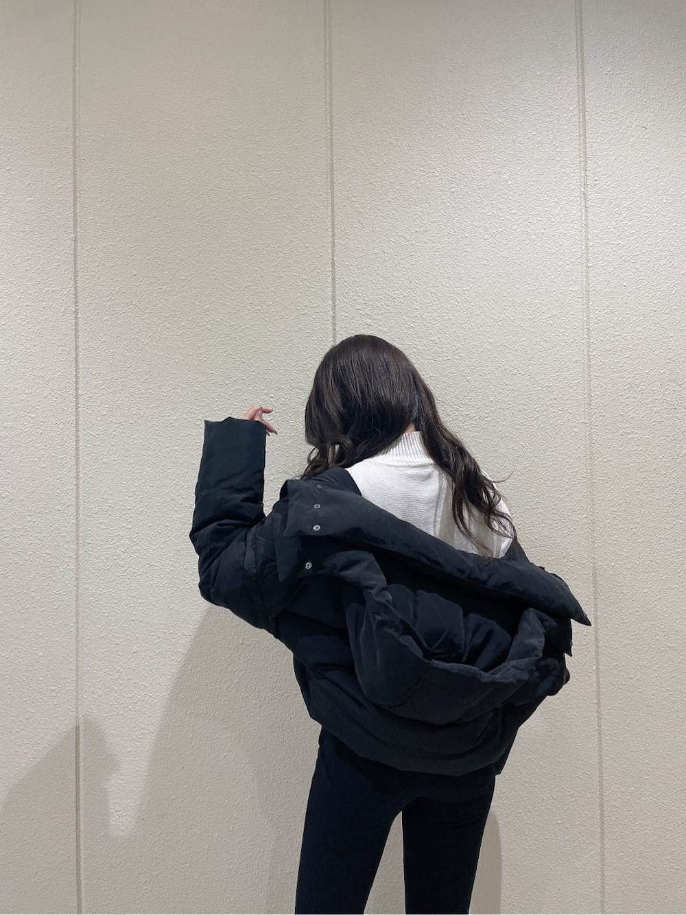 ブラック系のブーツ、ブラック系のダウンジャケット/コート、ホワイト系のニット/セーターを着用したレディースの秋コーディネートの7枚目の写真