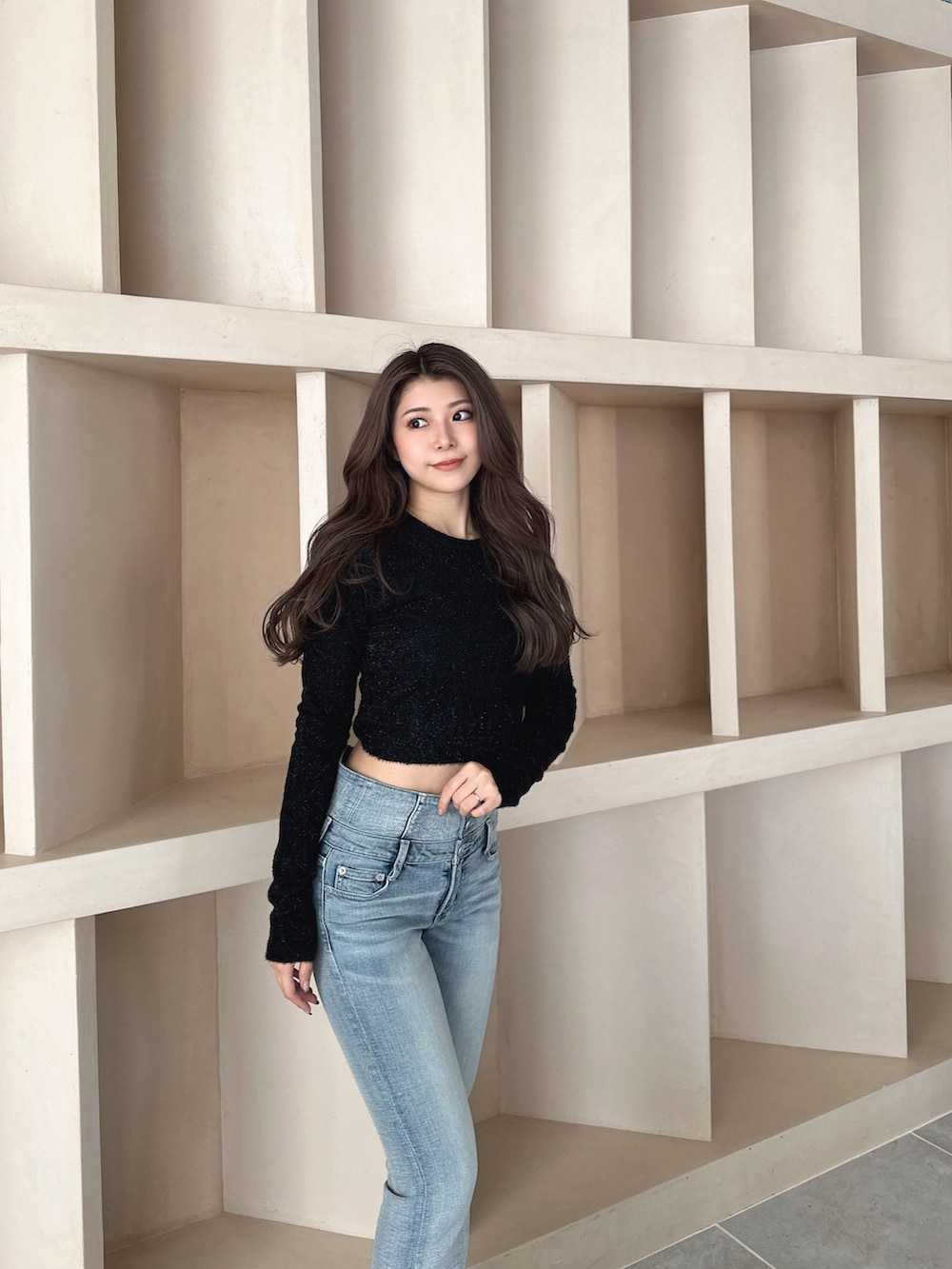 ブラック系のブーツ、ブルー系のデニムパンツ、ブラック系のニット/セーターを着用したレディースの秋コーディネートの5枚目の写真