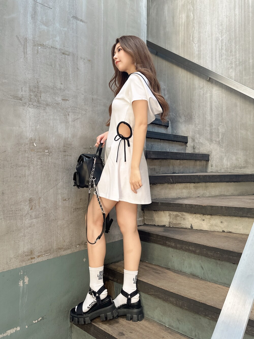 ホワイト系のワンピース、ブラック系のサンダル、ブラック系のバックパック/リュックを着用したレディースの夏コーディネートの2枚目の写真