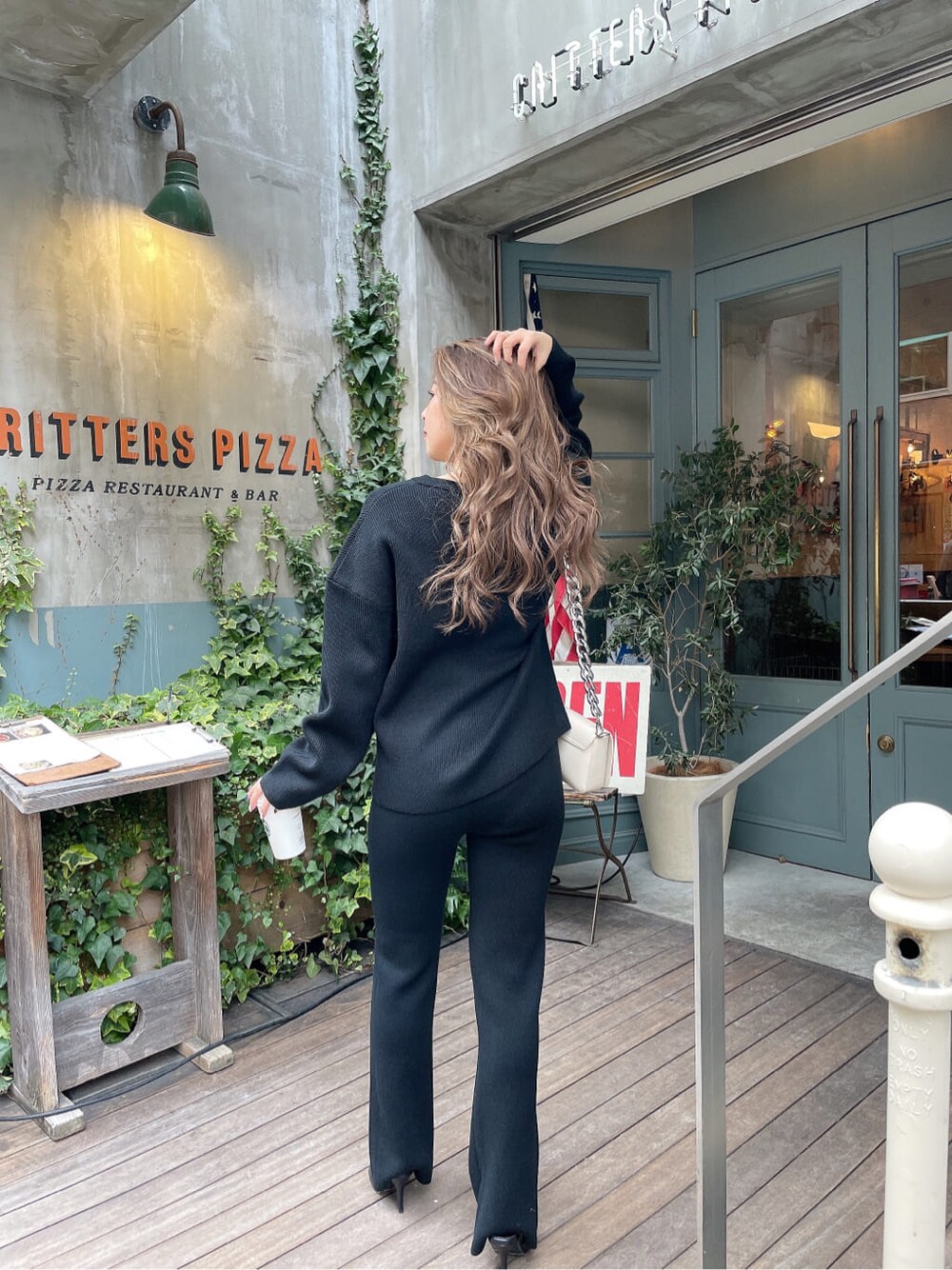 ホワイト系のショルダーバッグ、ブラック系のパンプス、ブラック系のその他パンツを着用したレディースの冬コーディネートの3枚目の写真