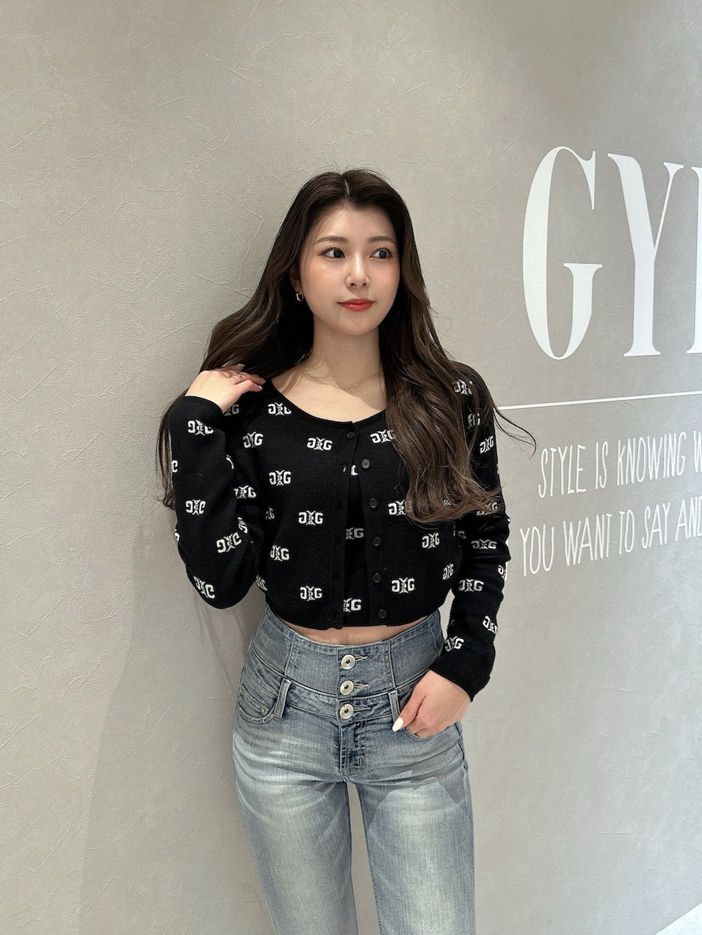 ブラック系のニット/セーター、ブルー系のデニムパンツ、ブラック系のパンプスを着用したレディースの春コーディネートの4枚目の写真