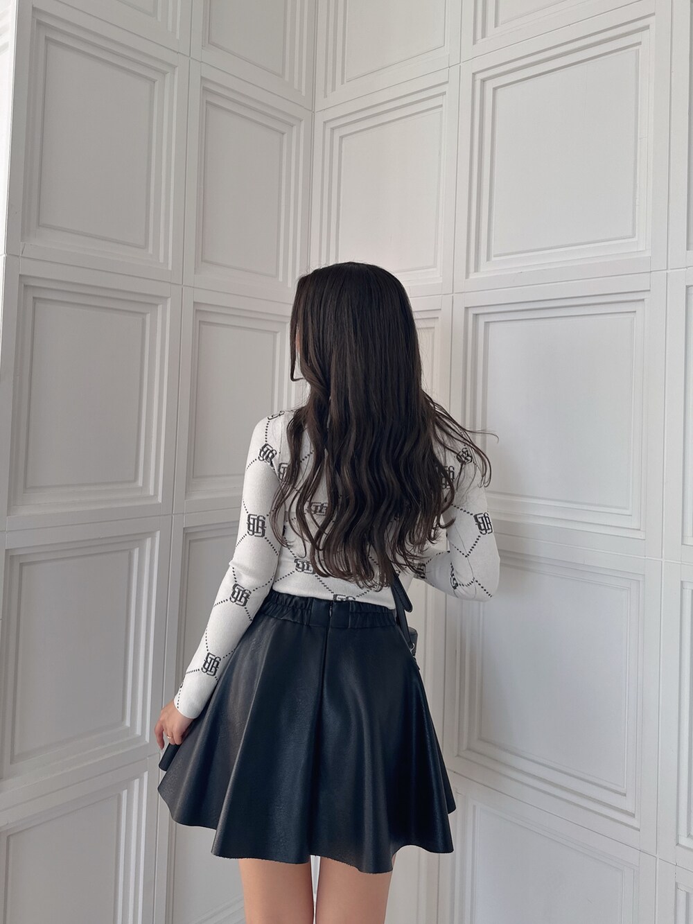 ブラック系のスカート、ブラック系のハンドバッグ、ホワイト系のニット/セーターを着用したレディースの冬コーディネートの8枚目の写真