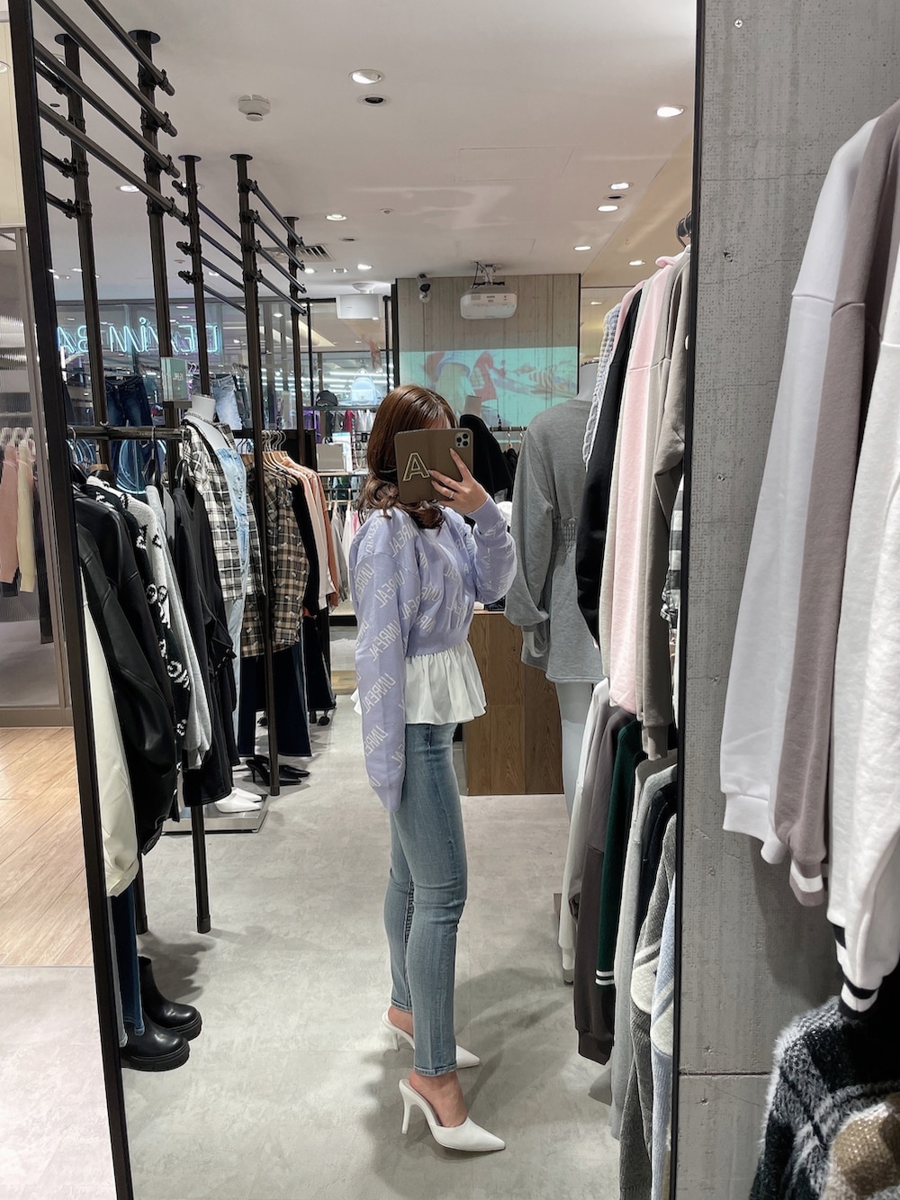 パープル系のニット/セーター、ホワイト系のシャツ/ブラウス、ブルー系のデニムパンツを着用したレディースの冬コーディネートの2枚目の写真