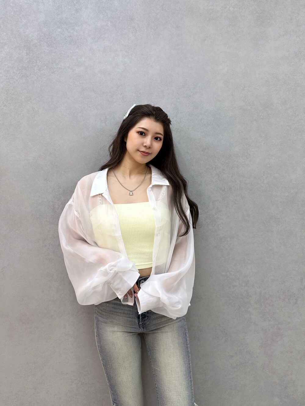 イエロー系のキャミソール、ホワイト系のシャツ/ブラウス、ブルー系のデニムパンツを着用したレディースの春コーディネートの3枚目の写真