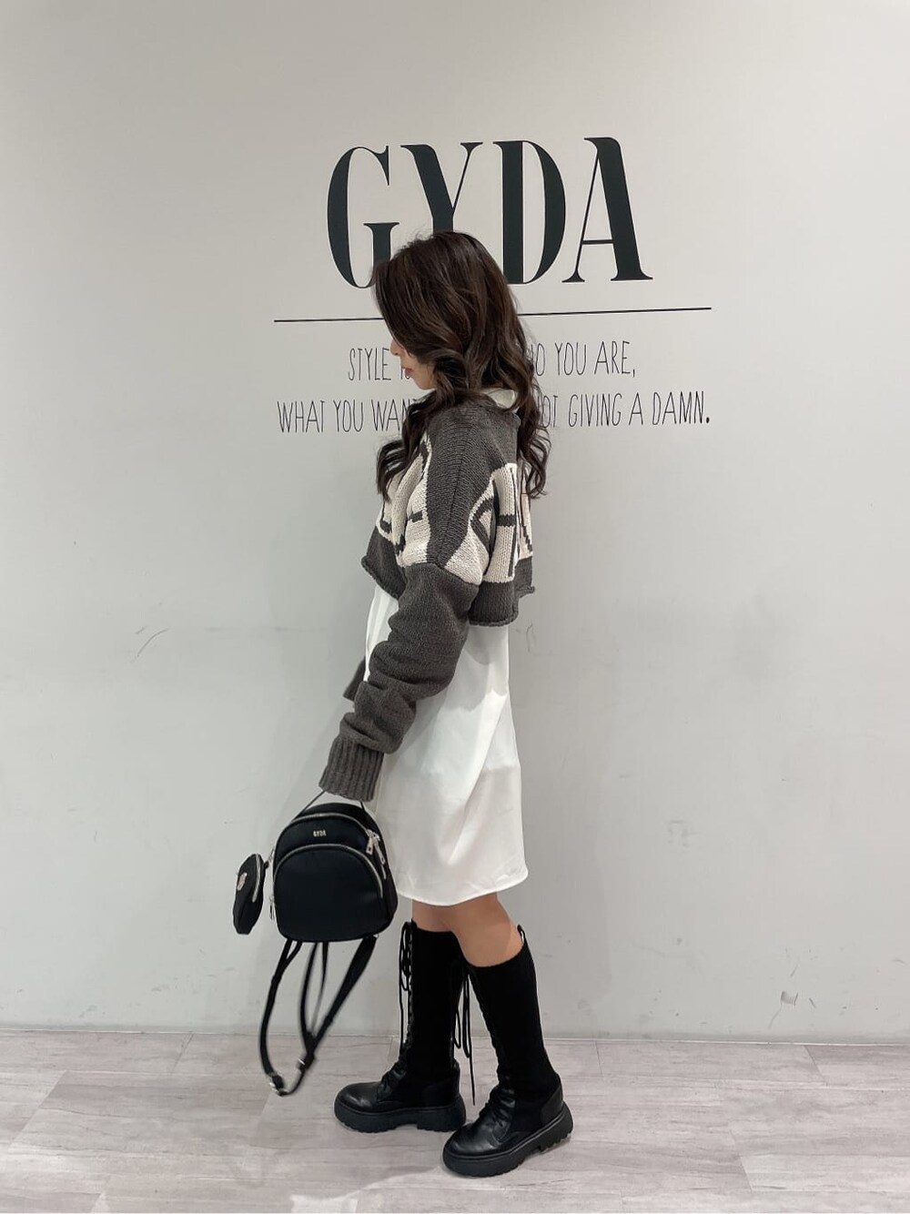 ブラック系のその他シューズ、ブラック系のバックパック/リュック、ホワイト系のシャツ/ブラウスを着用したレディースの冬コーディネートの3枚目の写真