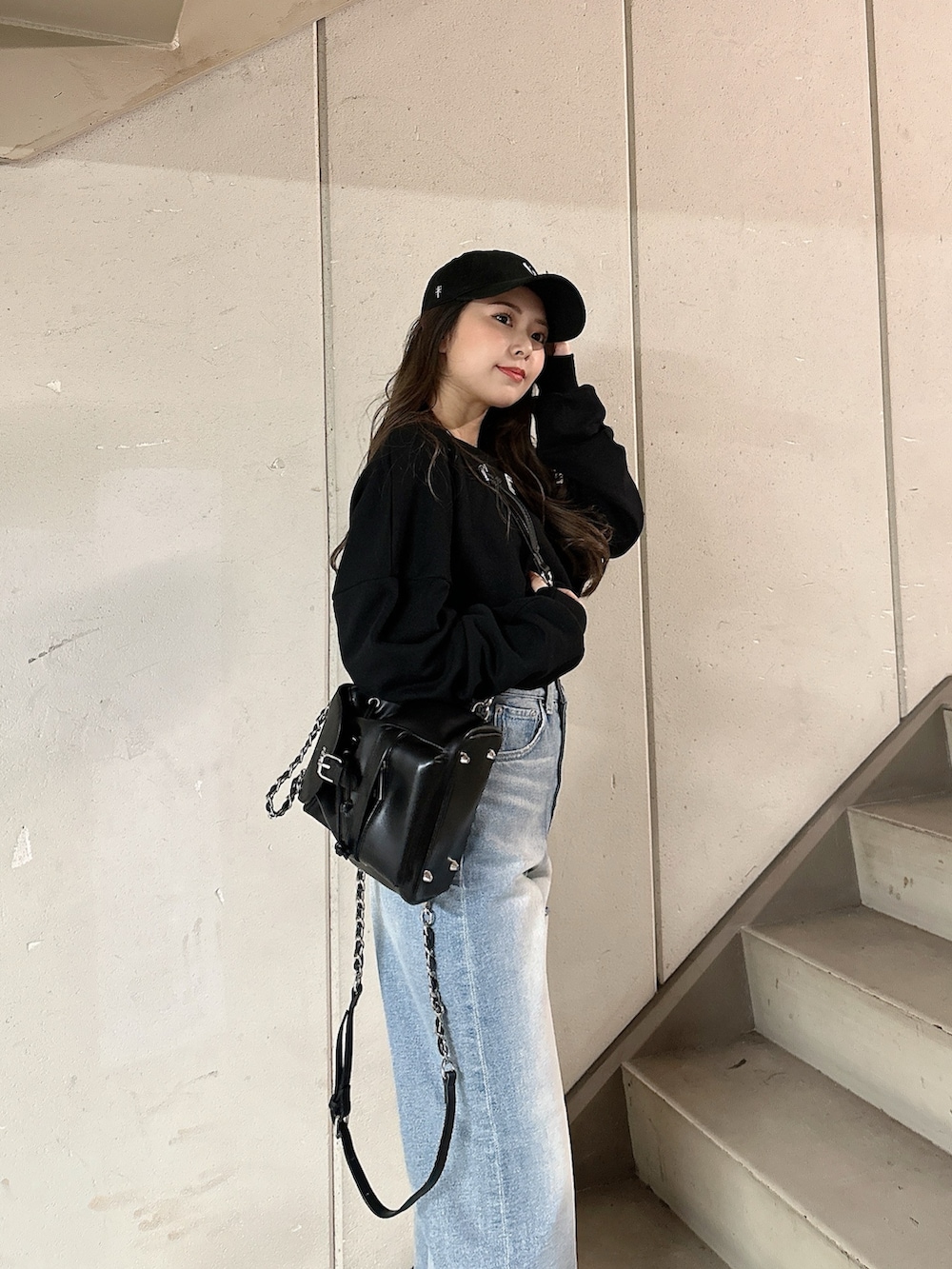 ブラック系のスウェット、ブルー系のデニムパンツ、ブラック系のバックパック/リュックを着用したレディースの冬コーディネートの7枚目の写真