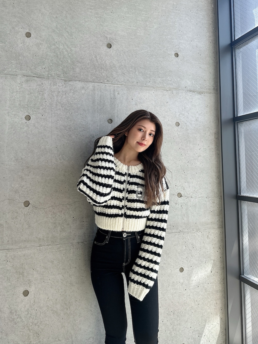 ブラック系のブーツ、ブラック系のデニムパンツ、その他のカーディガン/ボレロを着用したレディースの秋コーディネートの3枚目の写真