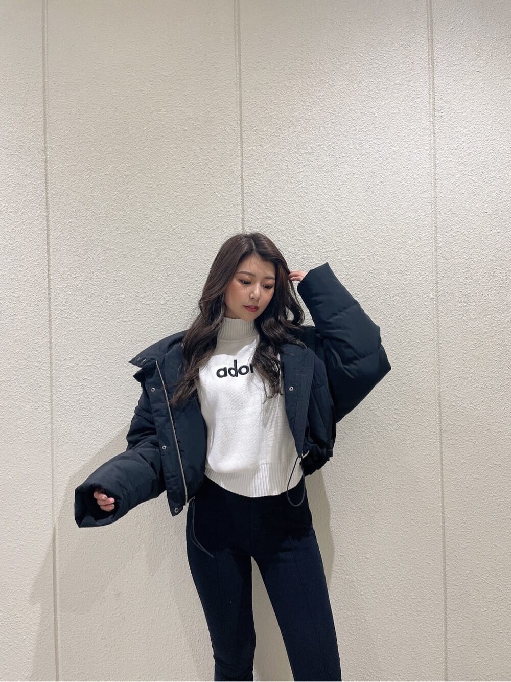 ブラック系のブーツ、ブラック系のダウンジャケット/コート、ホワイト系のニット/セーターを着用したレディースの秋コーディネートの5枚目の写真