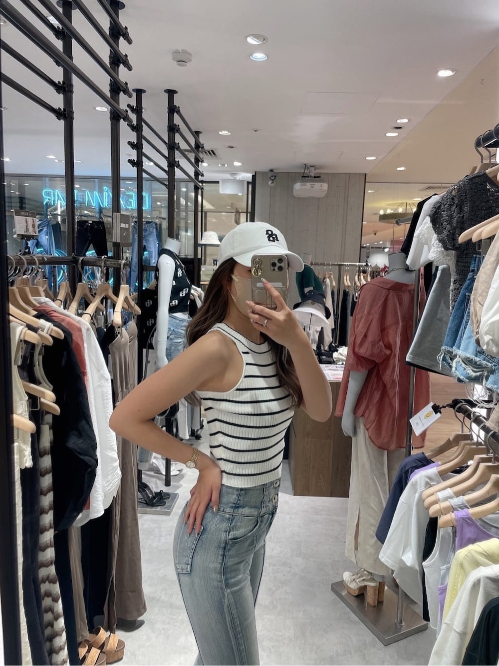 ホワイト系のサンダル、ホワイト系のタンクトップ、ブルー系のデニムパンツを着用したレディースの夏コーディネートの5枚目の写真