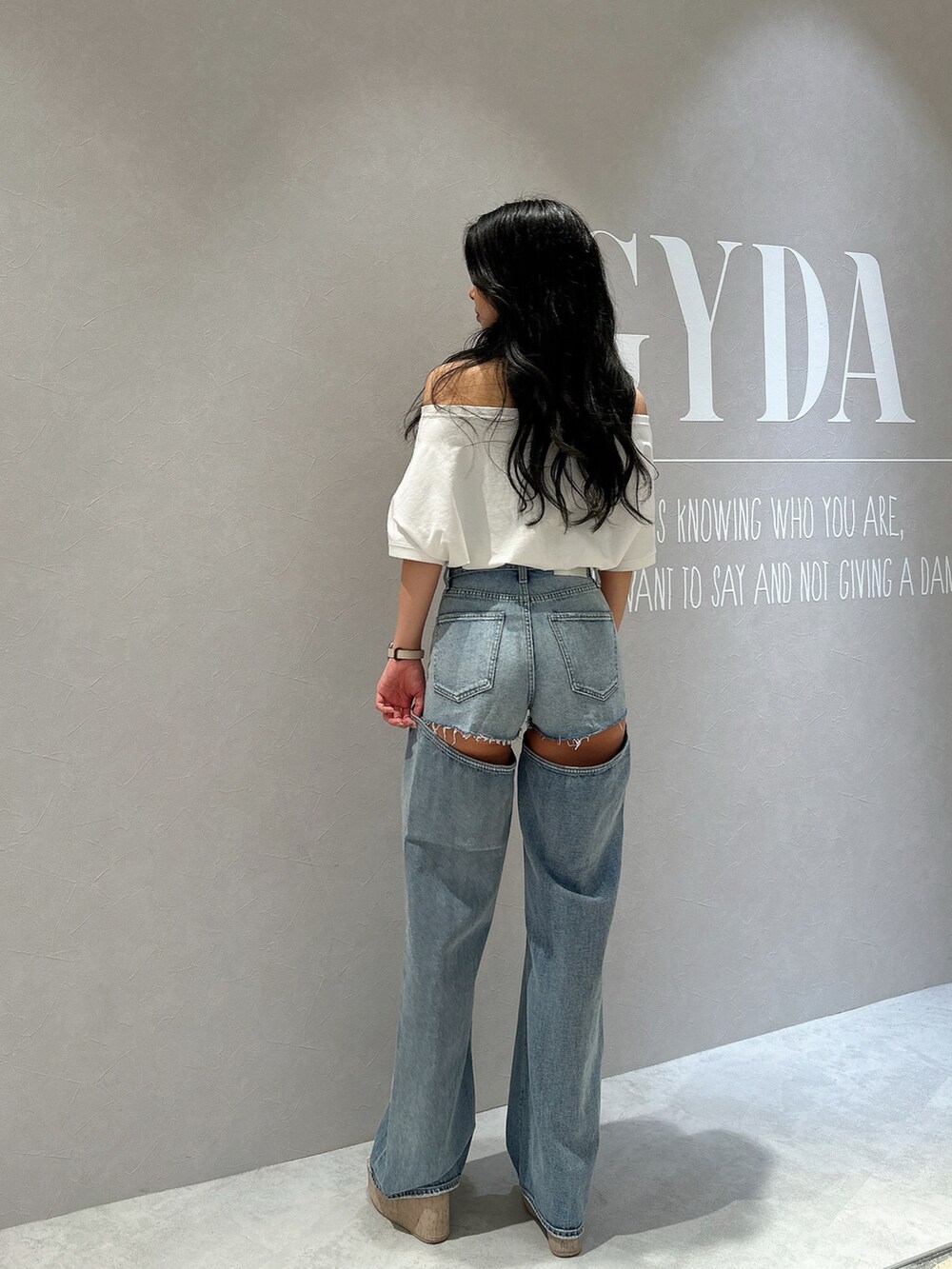 ホワイト系のサンダル、ホワイト系のTシャツ/カットソー、ブルー系のデニムパンツを着用したレディースの夏コーディネートの3枚目の写真