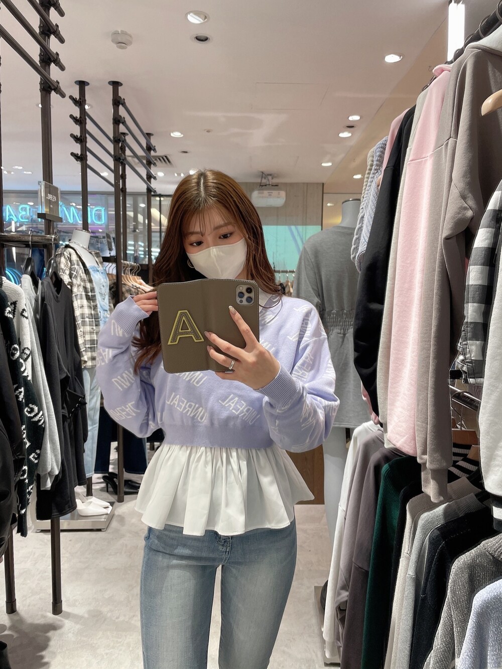 パープル系のニット/セーター、ホワイト系のシャツ/ブラウス、ブルー系のデニムパンツを着用したレディースの冬コーディネートの6枚目の写真