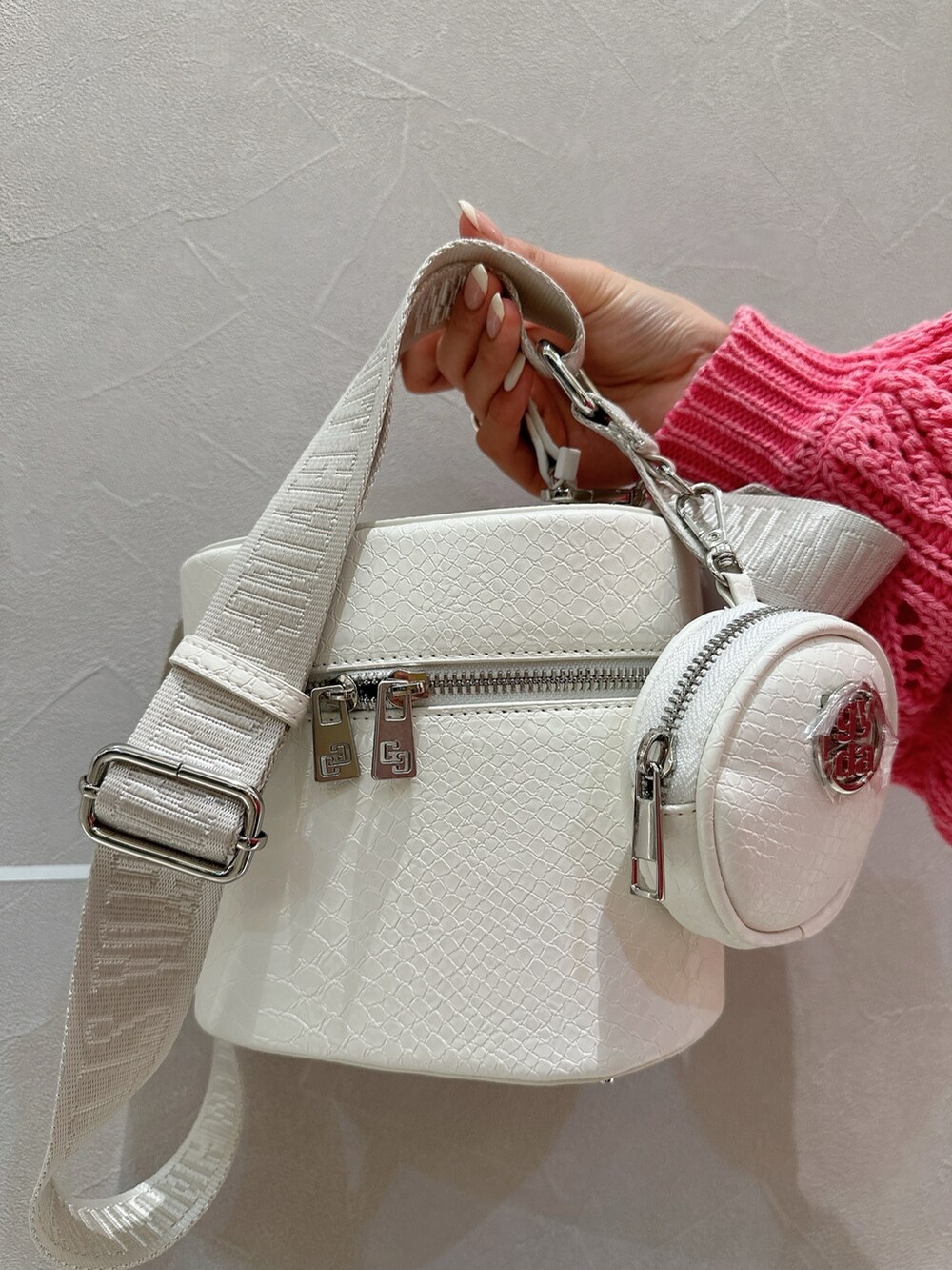 ピンク系のカーディガン/ボレロ、ブルー系のキャミソール、ホワイト系のハンドバッグを着用したレディースの春コーディネートの9枚目の写真