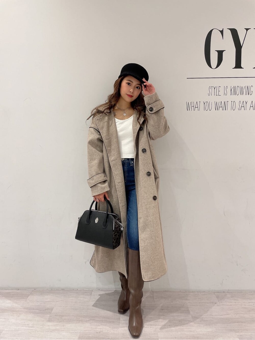 ブラウン系のブーツ、ブルー系のデニムパンツ、ホワイト系のTシャツ/カットソーを着用したレディースの秋コーディネートの2枚目の写真