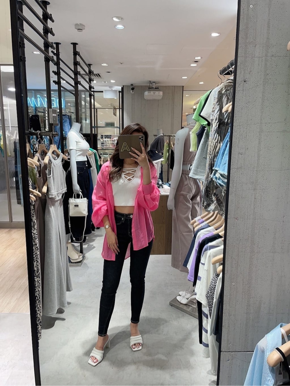 ブラック系のデニムパンツ、ホワイト系のサンダル、ホワイト系のTシャツ/カットソーを着用したレディースの夏コーディネートの5枚目の写真