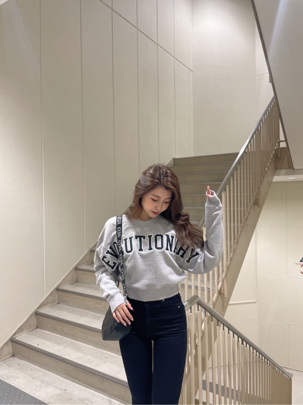 その他のデニムパンツ、ブラック系のブーツ、グレー系のスウェットを着用したレディースの秋コーディネートの5枚目の写真