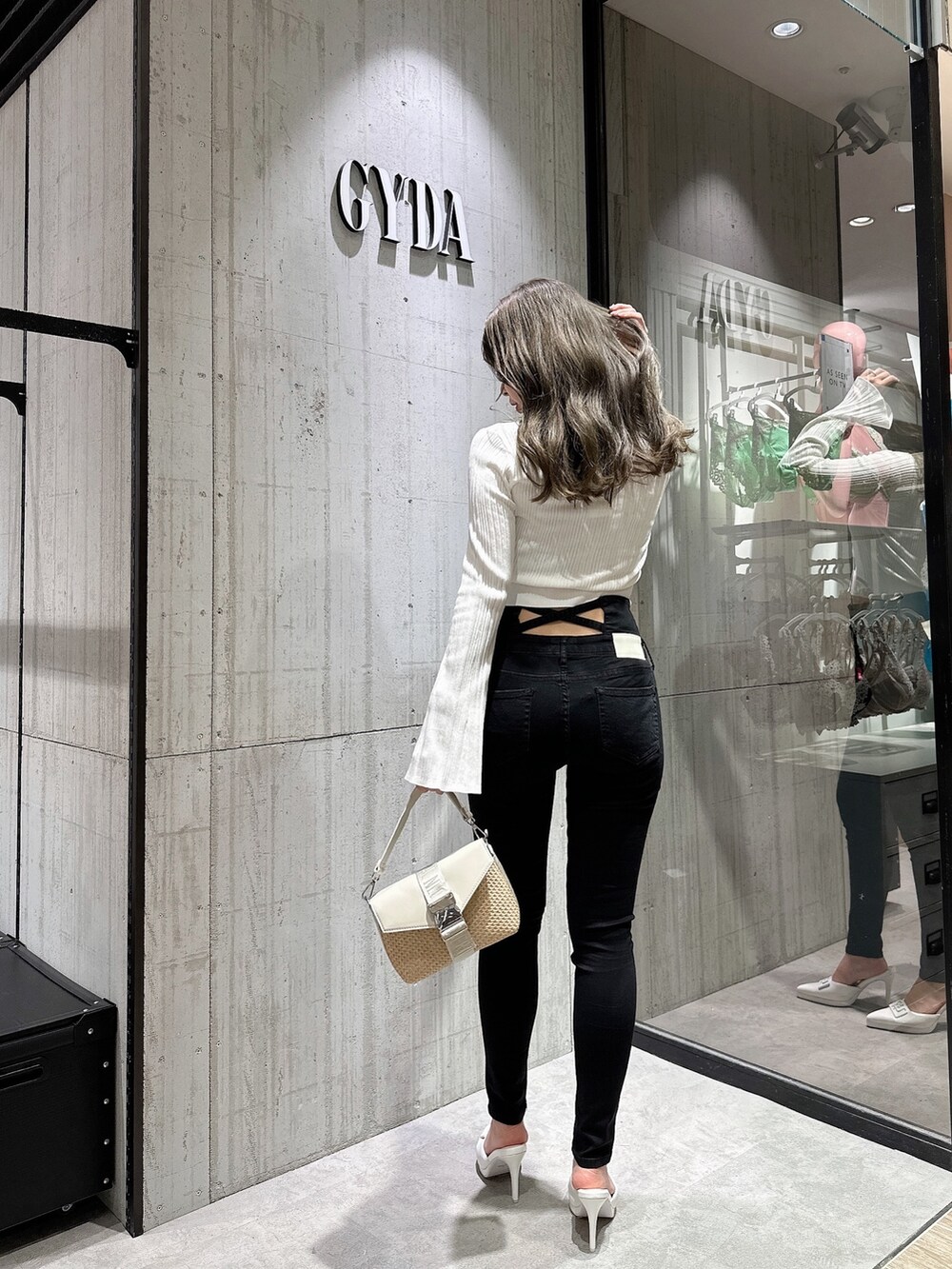 ホワイト系のカーディガン/ボレロ、ブラック系のデニムパンツ、ホワイト系のパンプスを着用したレディースの夏コーディネートの2枚目の写真