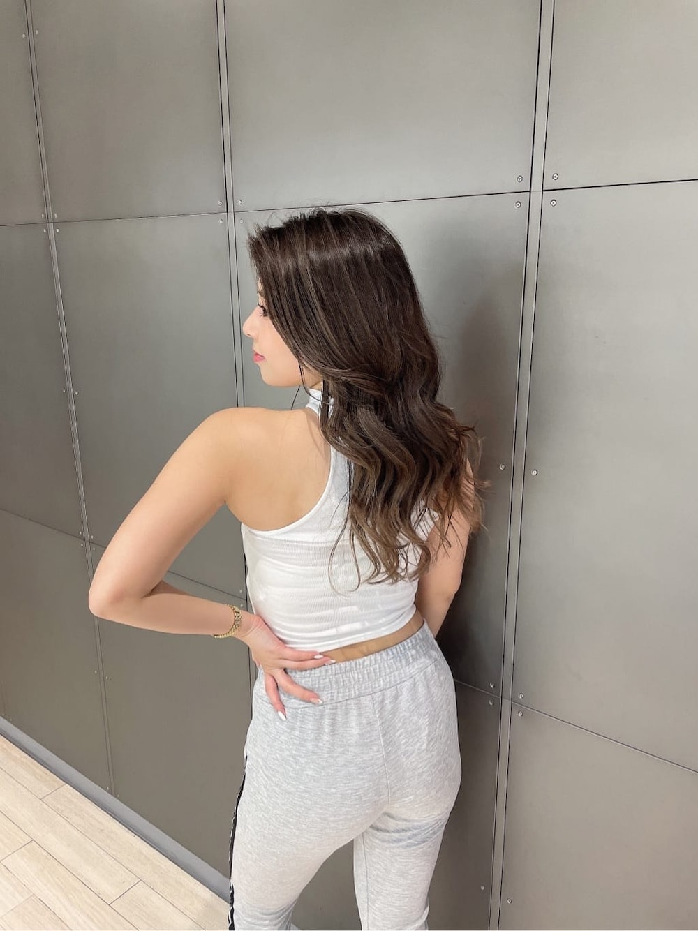 ブラック系のパンプス、グレー系のその他パンツ、ホワイト系のチューブトップを着用したレディースの春コーディネートの6枚目の写真