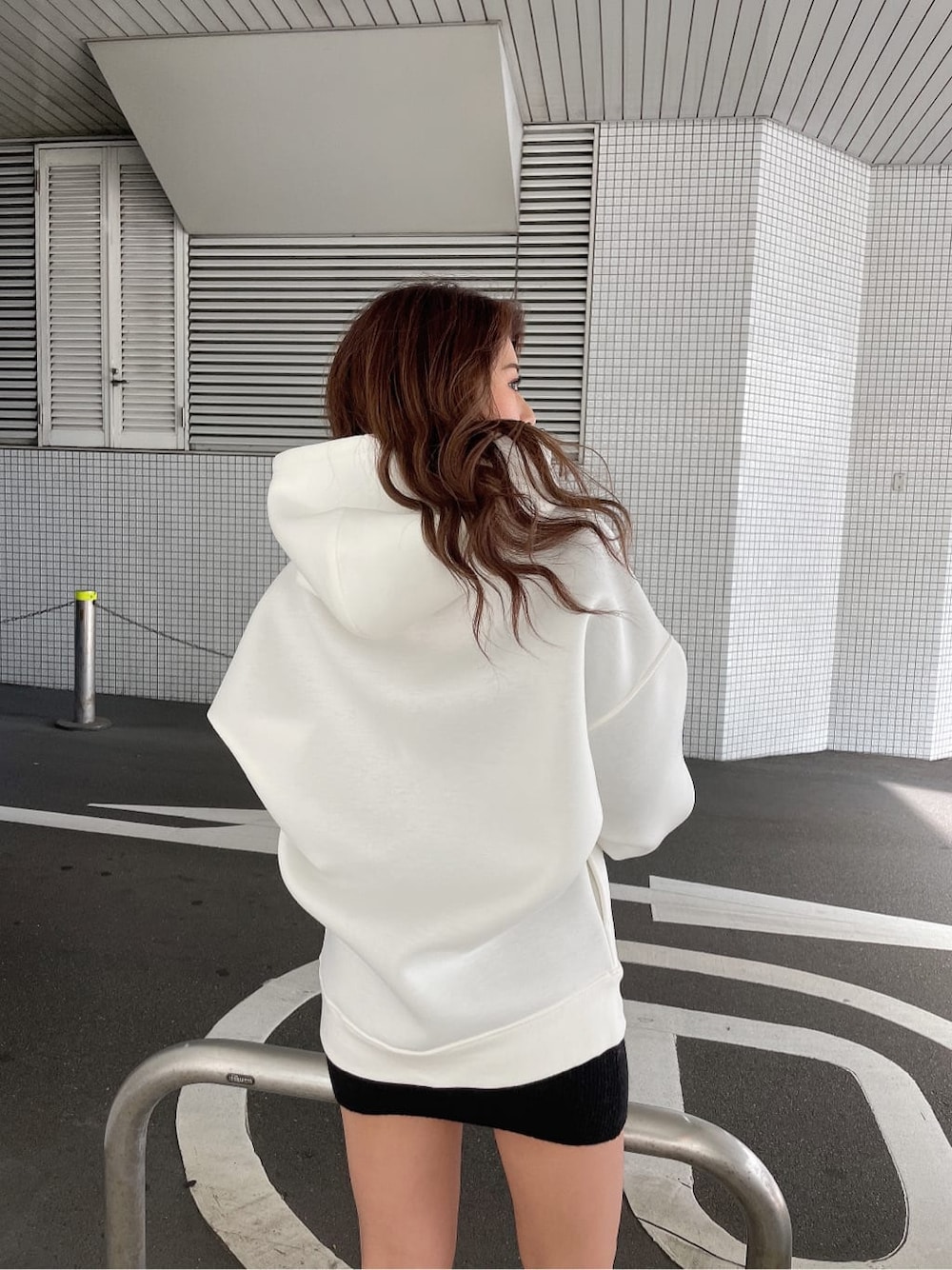 ブラック系のワンピース、ブラック系のブーツ、ホワイト系のTシャツ/カットソーを着用したレディースの冬コーディネートの5枚目の写真