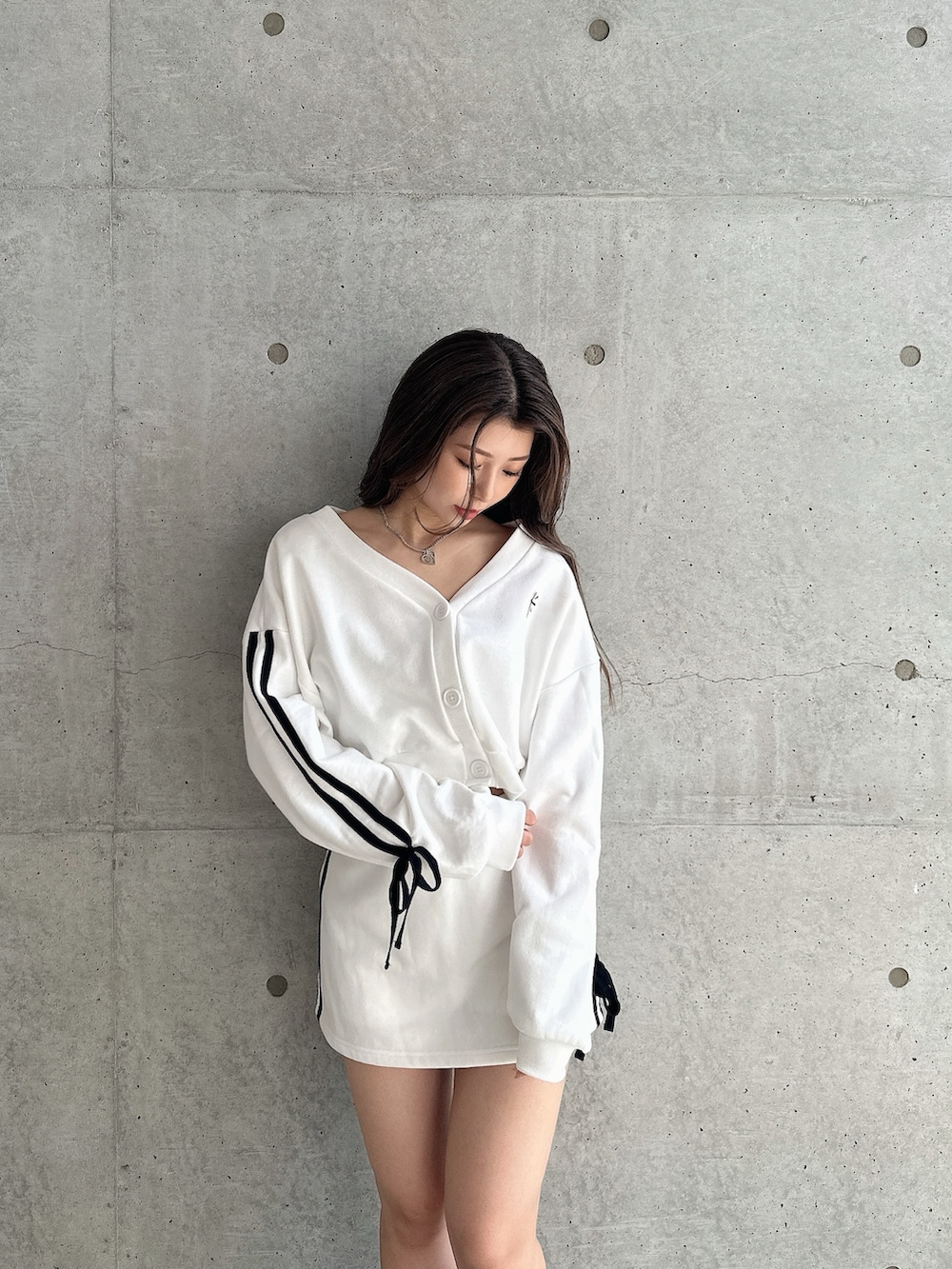 ホワイト系のカーディガン/ボレロ、ホワイト系のスカート、ブラック系のブーツを着用したレディースの秋コーディネートの3枚目の写真