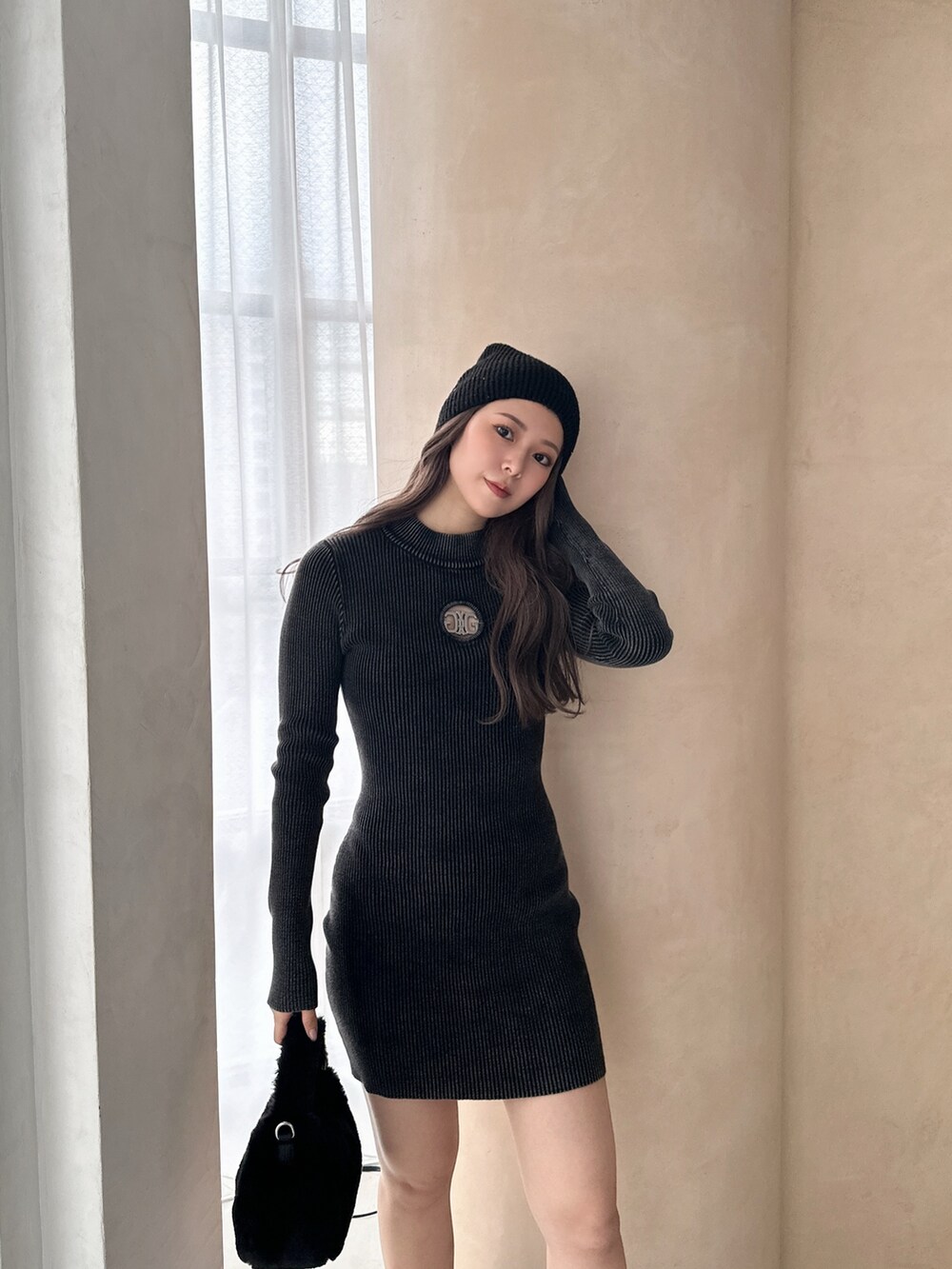 ブラック系のワンピース、ブラック系のブーツ、ブラック系のニットキャップ/ビーニーを着用したレディースの冬コーディネートの7枚目の写真