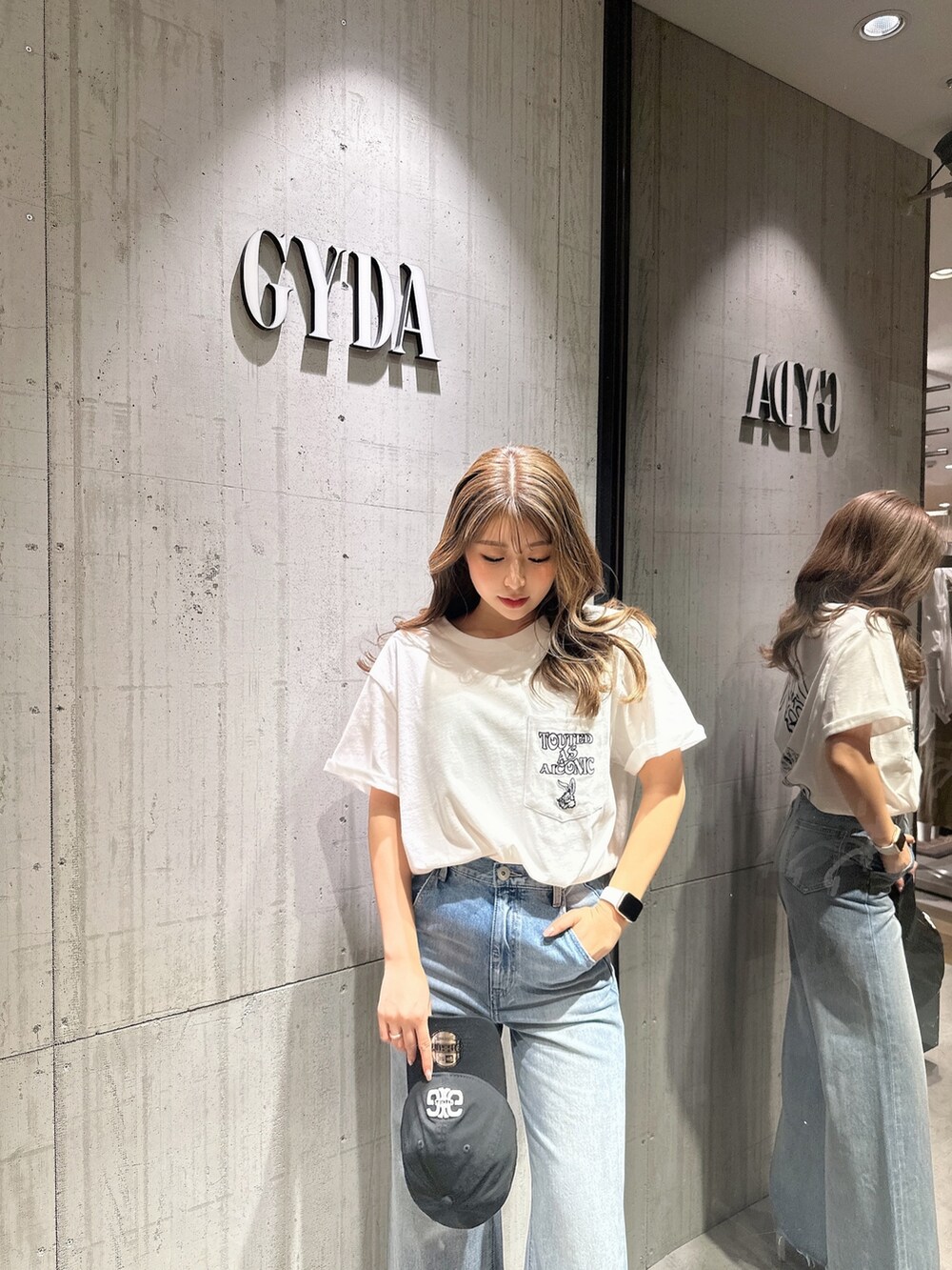 ブルー系のデニムパンツ、ホワイト系のサンダルを着用したレディースの夏コーディネートの7枚目の写真