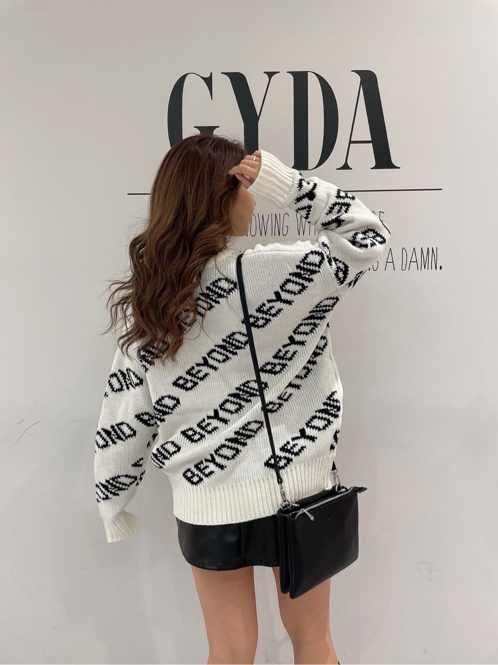 ブラック系のショルダーバッグ、ブラック系のスカート、ブラック系のその他シューズを着用したレディースの冬コーディネートの7枚目の写真