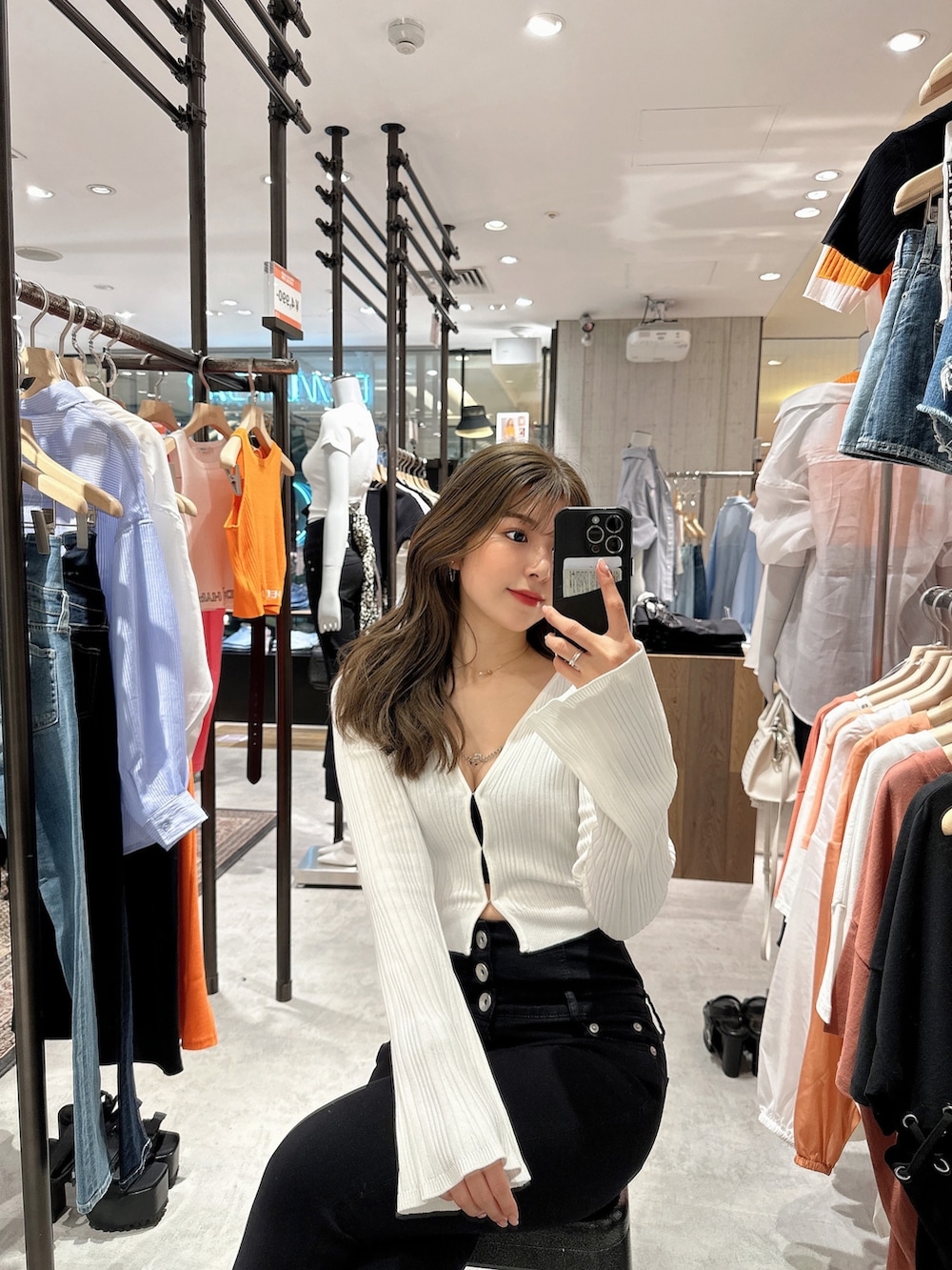 ホワイト系のカーディガン/ボレロ、ブラック系のデニムパンツ、ホワイト系のパンプスを着用したレディースの夏コーディネートの7枚目の写真