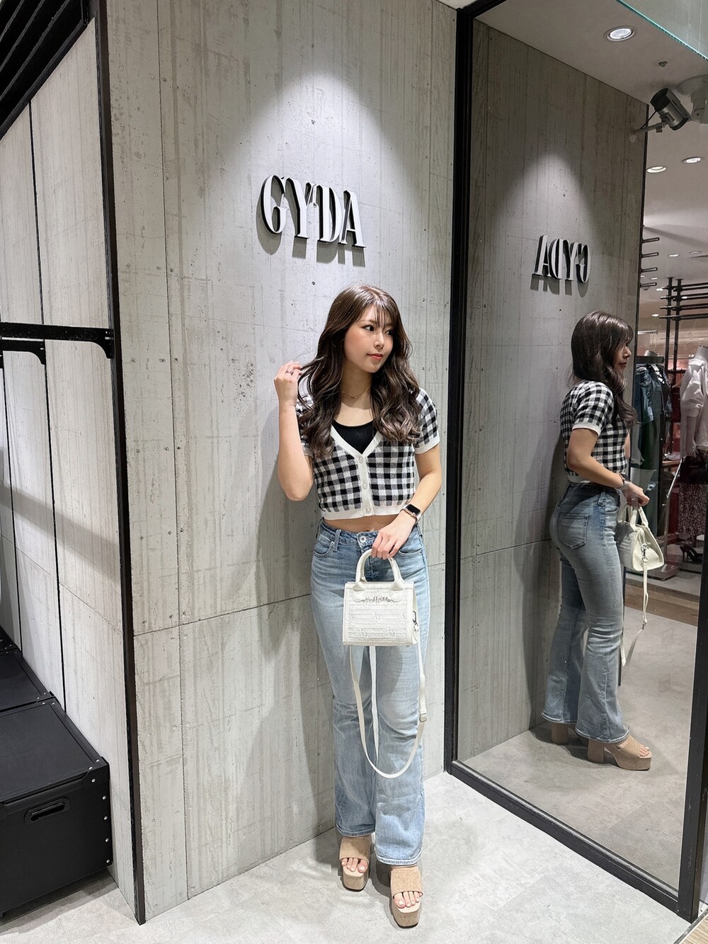 ブラック系のTシャツ/カットソー、ブラック系のカーディガン/ボレロ、ブルー系のデニムパンツを着用したレディースの春コーディネートの2枚目の写真