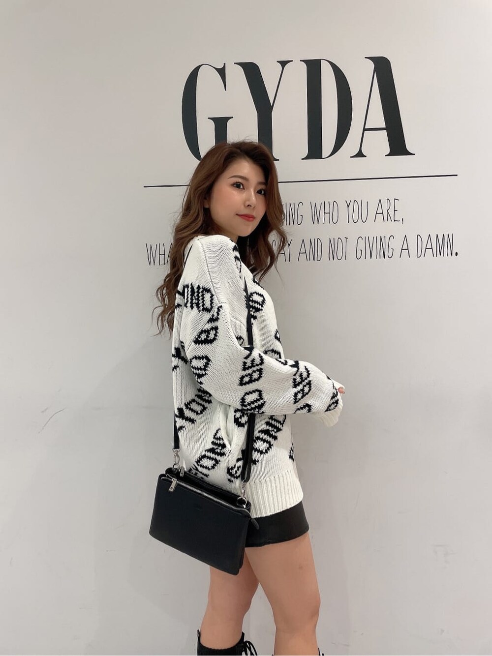 ブラック系のショルダーバッグ、ブラック系のスカート、ブラック系のその他シューズを着用したレディースの冬コーディネートの6枚目の写真