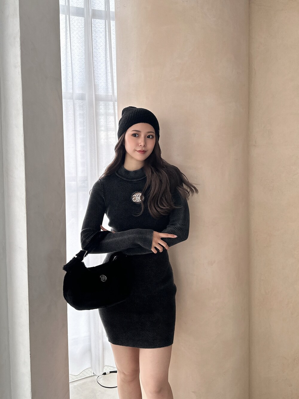 ブラック系のワンピース、ブラック系のブーツ、ブラック系のニットキャップ/ビーニーを着用したレディースの冬コーディネートの4枚目の写真