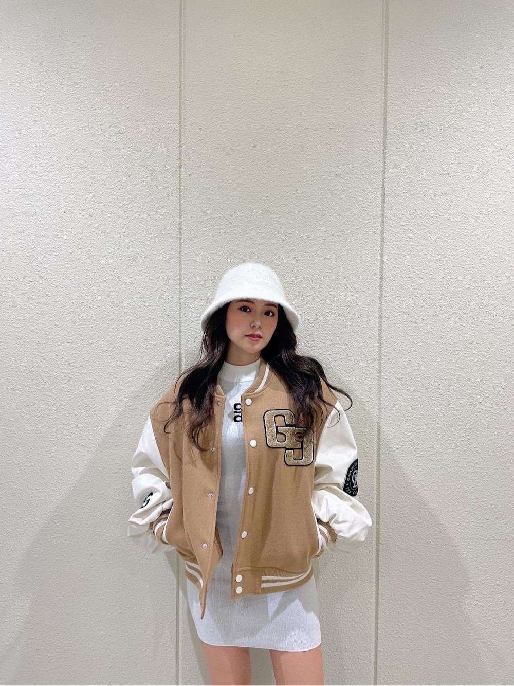 ベージュ系のスタジャン、ブラック系のブーツ、ホワイト系のワンピースを着用したレディースの秋コーディネートの5枚目の写真