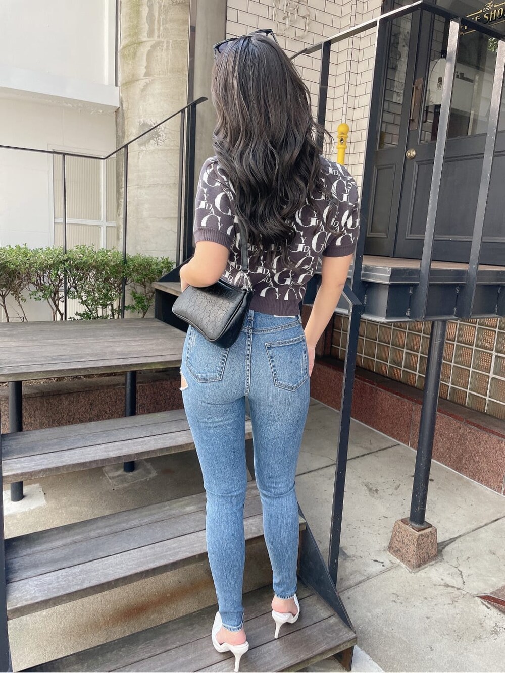 ブルー系のデニムパンツ、ホワイト系のパンプス、グレー系のニット/セーターを着用したレディースの冬コーディネートの3枚目の写真