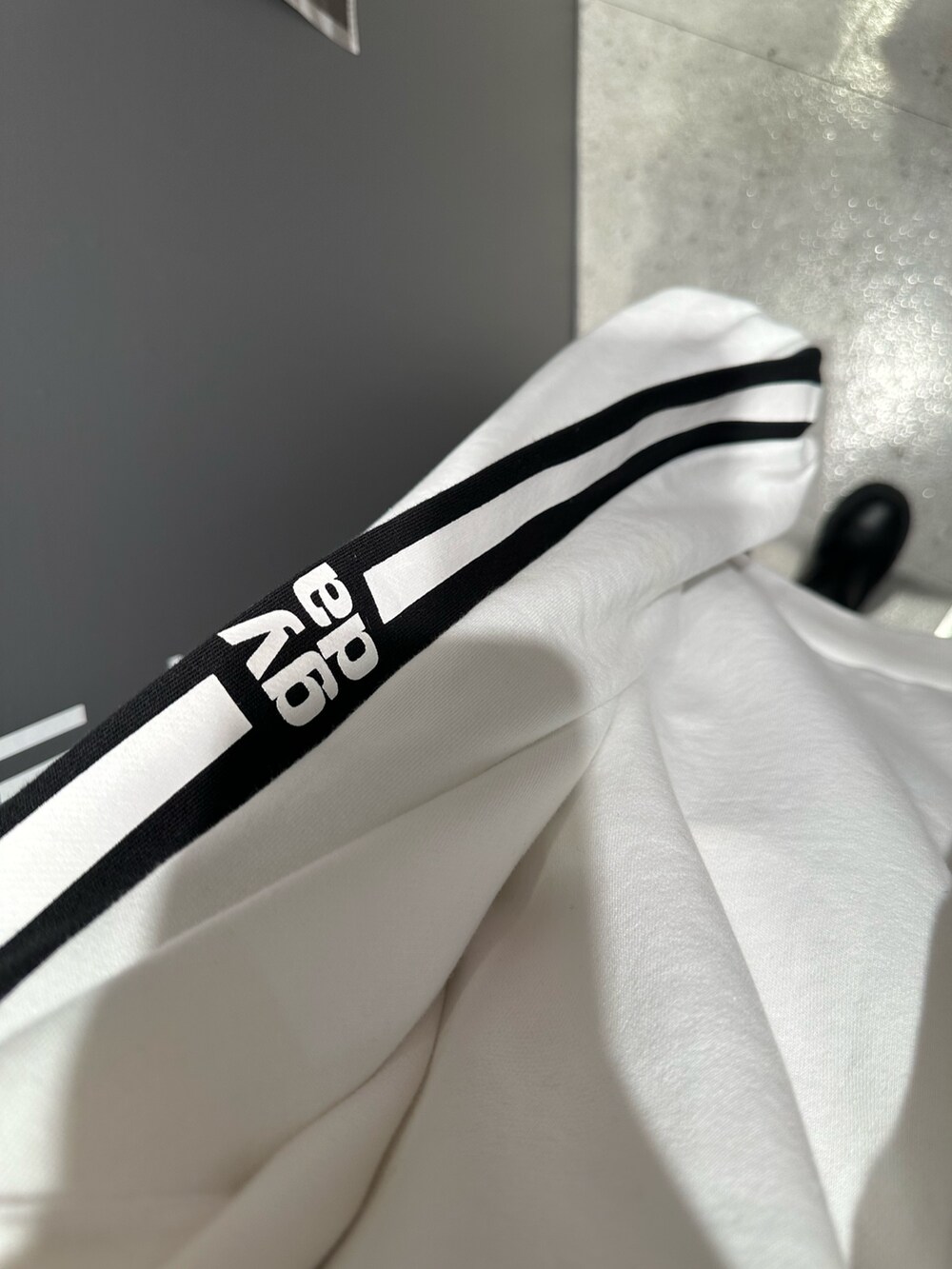 ホワイト系のスウェット、ブラック系のデニムパンツを着用したレディースの冬コーディネートの7枚目の写真