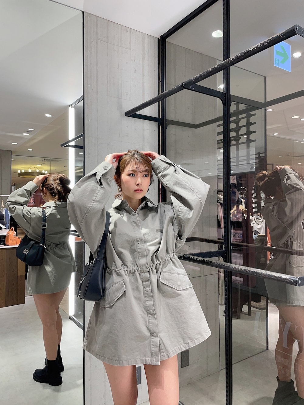 グレー系のミリタリージャケット、ホワイト系のハンドバッグ、ブラック系のブーツを着用したレディースの春コーディネートの5枚目の写真