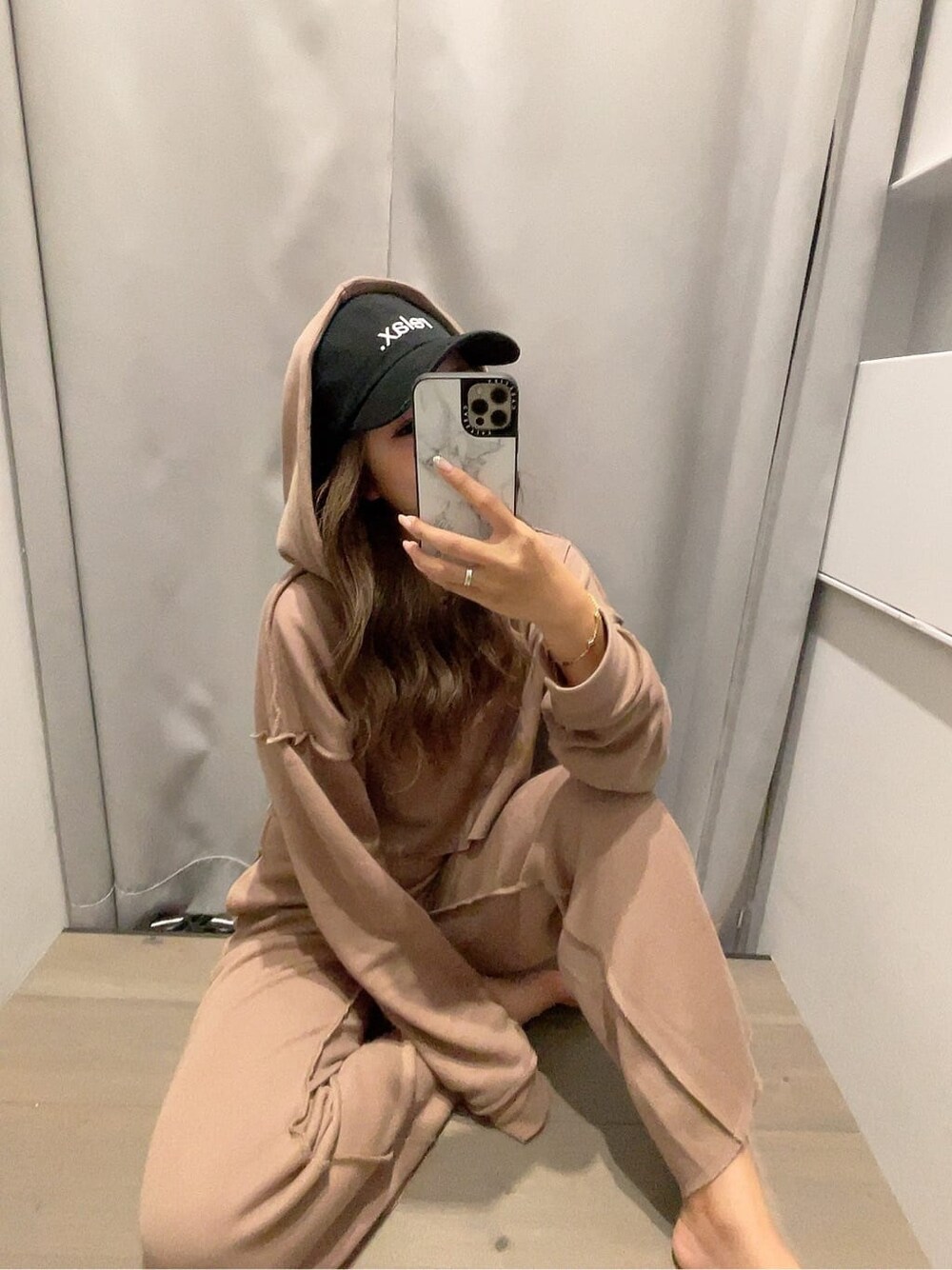 ベージュ系のその他パンツ、ベージュ系のパーカー、ブラック系のキャップを着用したレディースの夏コーディネートの2枚目の写真