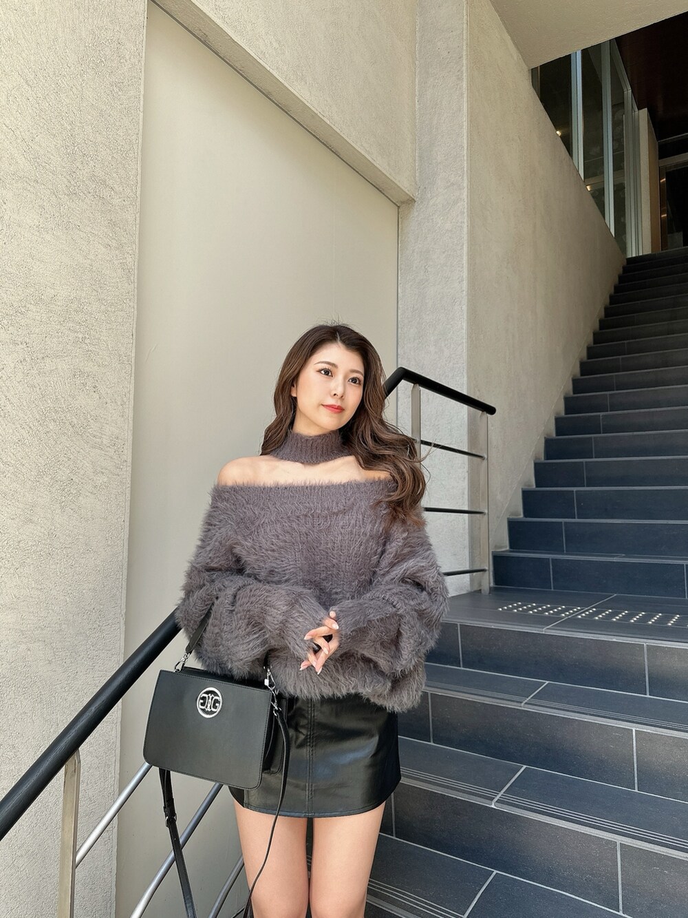 ホワイト系のニット/セーター、ブラック系のスカート、ブラック系のブーツを着用したレディースの冬コーディネートの6枚目の写真