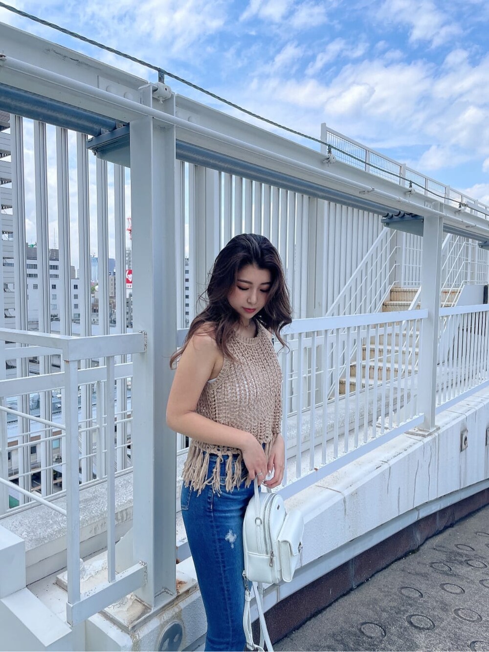 ホワイト系のサンダル、ブルー系のデニムパンツ、ホワイト系のハンドバッグを着用したレディースの夏コーディネートの5枚目の写真