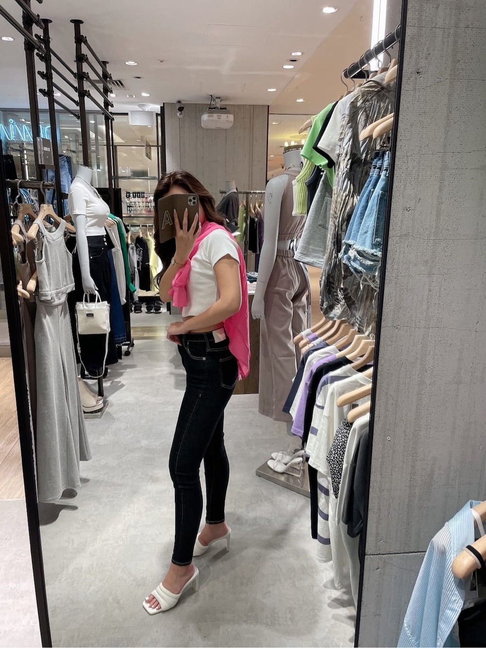 ブラック系のデニムパンツ、ホワイト系のサンダル、ホワイト系のTシャツ/カットソーを着用したレディースの夏コーディネートの3枚目の写真