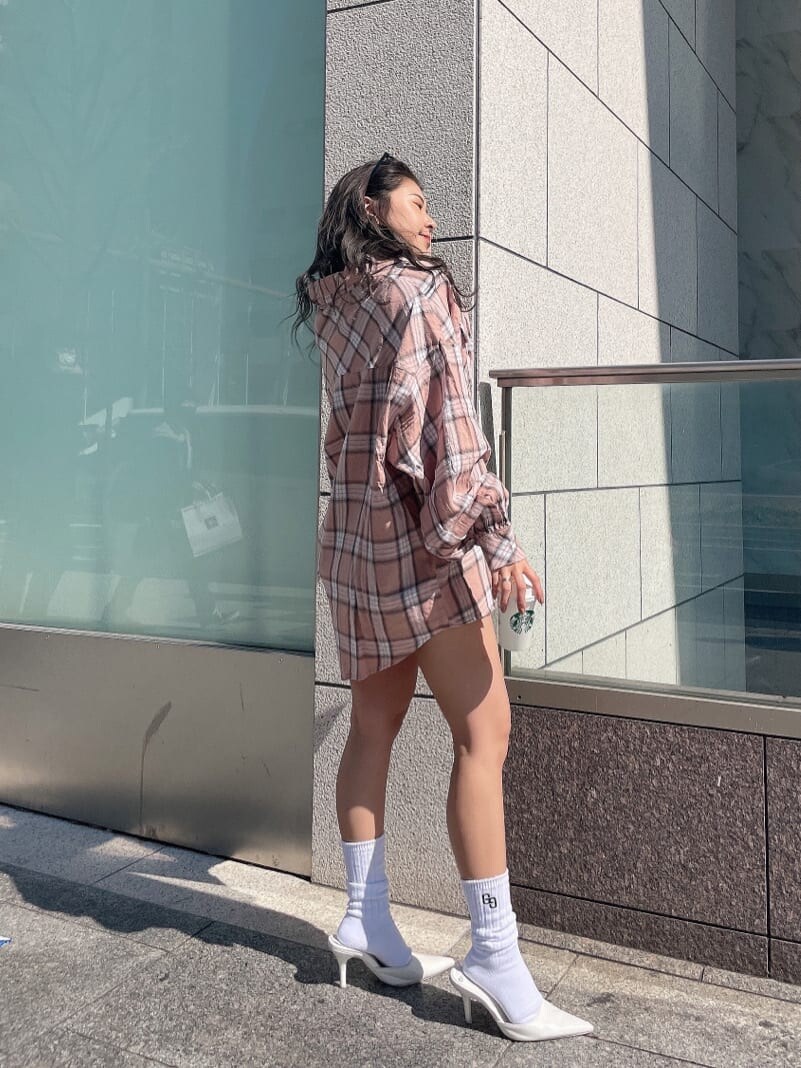 ホワイト系のパンプス、オレンジ系のシャツ/ブラウス、ブルー系のデニムパンツを着用したレディースの春コーディネートの3枚目の写真