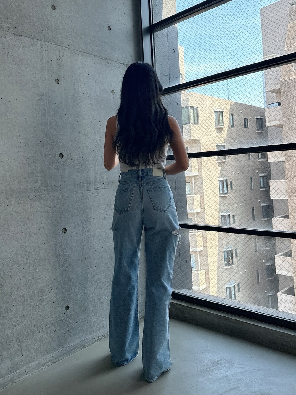 ホワイト系のパンプス、ホワイト系のタンクトップ、ブルー系のデニムパンツを着用したレディースの夏コーディネートの4枚目の写真