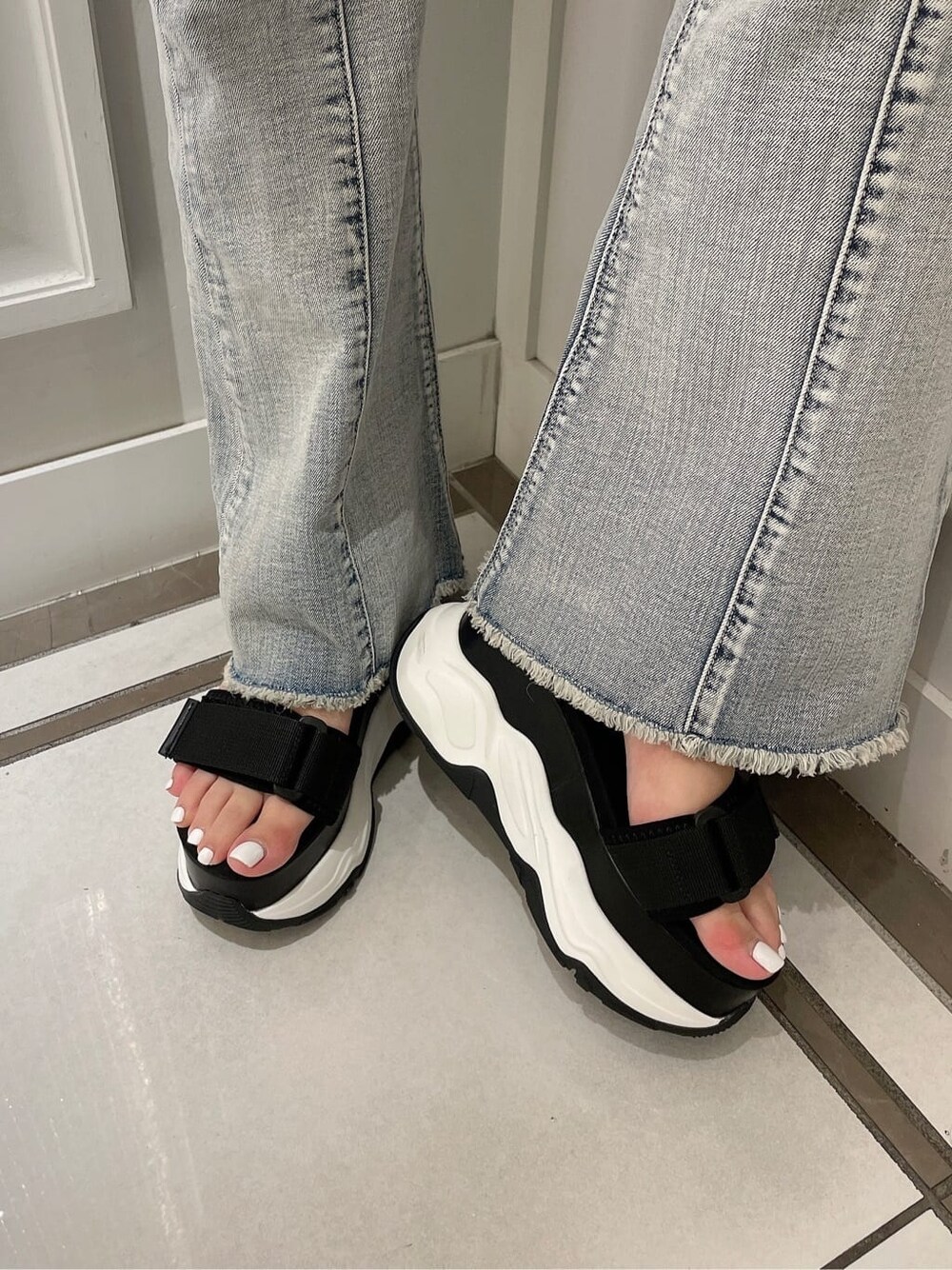 その他のサンダル、ホワイト系のTシャツ/カットソー、ブルー系のデニムパンツを着用したレディースの夏コーディネートの10枚目の写真